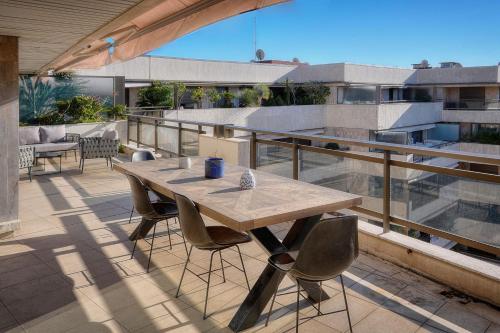 une table et des chaises en bois sur un balcon dans l'établissement REF 1174 - Apartment with Sea View, à Cannes