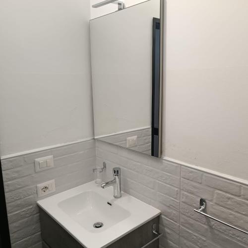 a bathroom with a sink and a large mirror at LOFT 85 in Baia Verde
