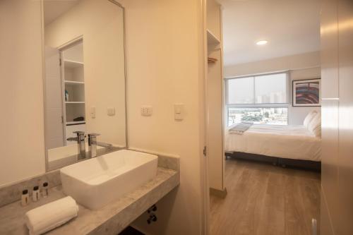 La salle de bains est pourvue d'un lavabo et d'un lit. dans l'établissement Grau by Wynwood House, à Lima