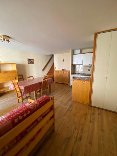 un salon avec une table et une cuisine dans l'établissement Les Gentianes, à Lanslebourg-Mont-Cenis