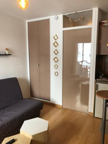 - un salon avec un canapé et une porte coulissante dans l'établissement Charmant Studio, à Allos