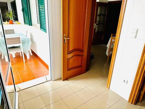 uma porta aberta para uma sala de jantar com uma mesa em Smarts Apartment da Ajuda no Funchal