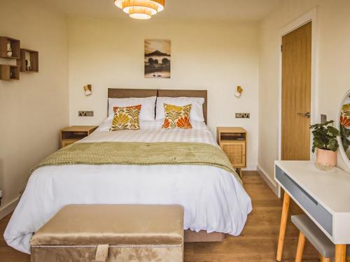um quarto com uma grande cama branca e 2 almofadas em Waters Edge - Uk44426 em Donyatt