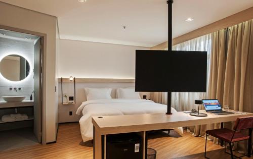 a hotel room with a bed and a desk with a computer at Intercity Porto Alegre Aeroporto in Porto Alegre