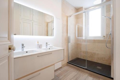 a bathroom with a sink and a glass shower at Luxe Poincare in Nancy