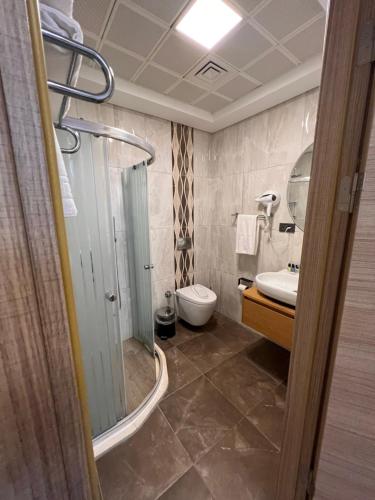 a bathroom with a shower and a toilet and a sink at Mavi Konak Alaçatı in Alaçatı