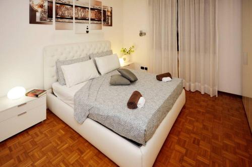 a bedroom with a large white bed with shoes on it at Elegance and comfort a due passi da SACILE CENTRO in Sacile