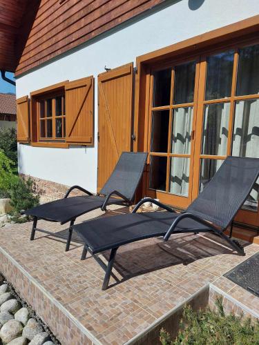 two lounge chairs on a patio in front of a house at Chata Lienka in Lazisko