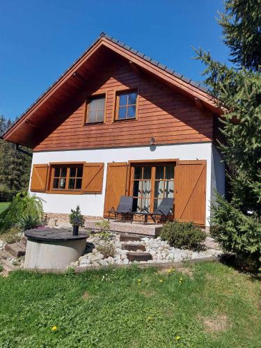 a house with wooden doors and a yard at Chata Lienka in Lazisko