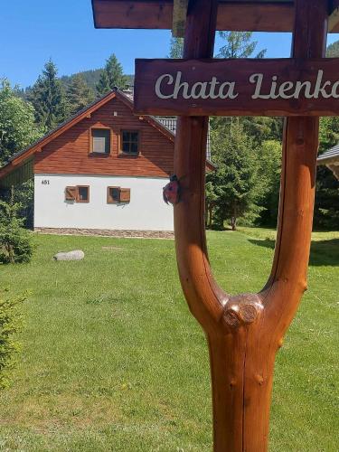 a wooden sign in front of a house at Chata Lienka in Lazisko