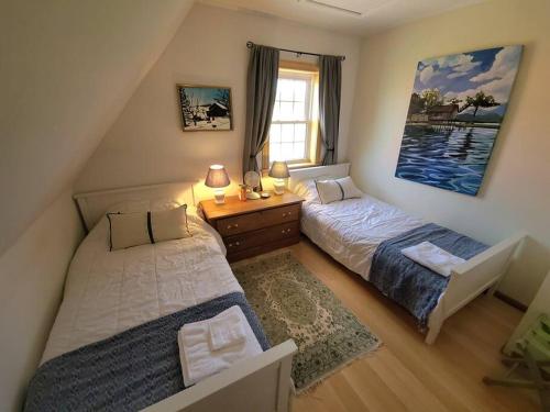 sypialnia z 2 łóżkami, biurkiem i oknem w obiekcie Margate Homestead 'Art House' /views/beaches/golf w mieście Kensington
