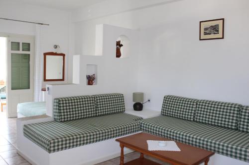 a living room with two couches and a table at Eleonas Apartments in Sifnos