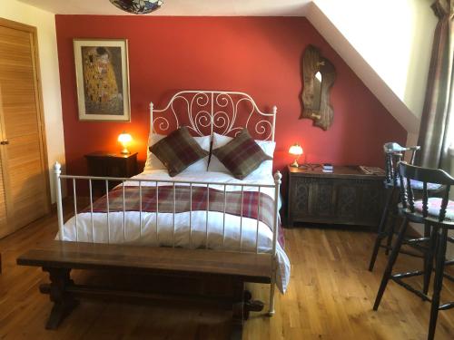 a bedroom with a bed and a red wall at Arisaig B&B Lovely Double Room Sea & Island Views in Arisaig