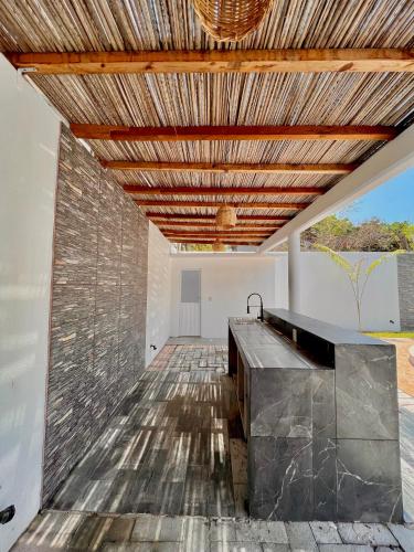 a kitchen with a stone wall and a wooden ceiling at Residencia en el centro de Puerto Escondido in Puerto Escondido