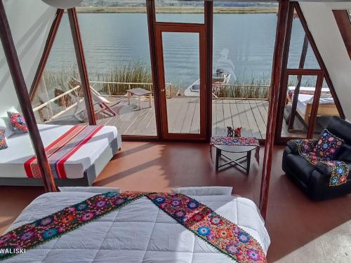 een slaapkamer met 2 bedden en uitzicht op de oceaan bij uros waliski alpina house in Puno