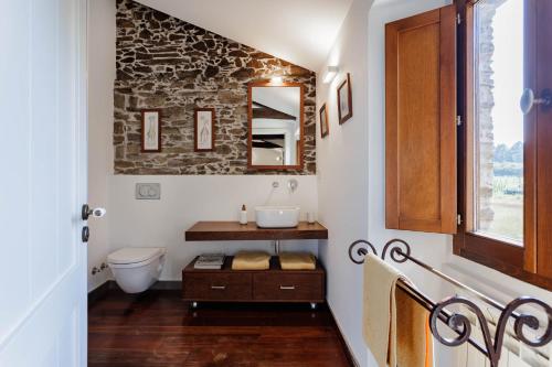 een badkamer met een wastafel en een toilet bij Eco molino rural in Abegondo