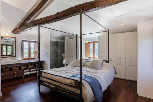 a bedroom with a canopy bed and white cabinets at Eco molino rural in Santa Eulalia