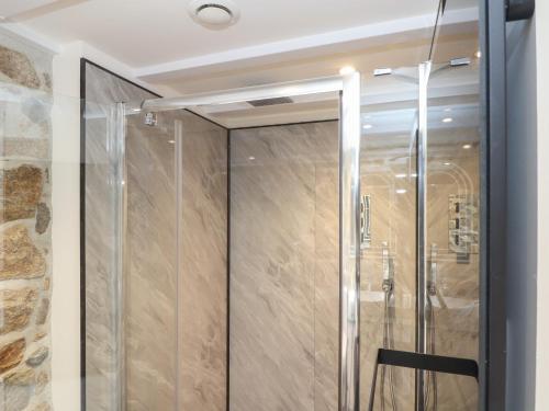 a shower with a glass door in a bathroom at The Hayloft in Helston