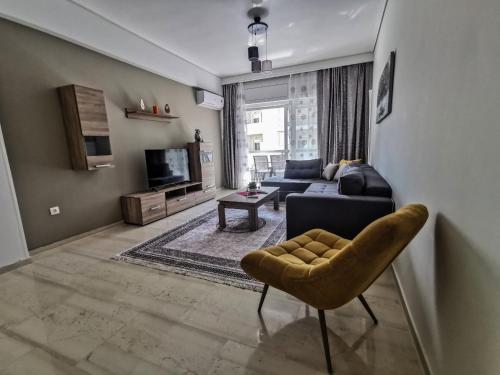 a living room with a couch and a chair at Silver Central Apartment in Volos