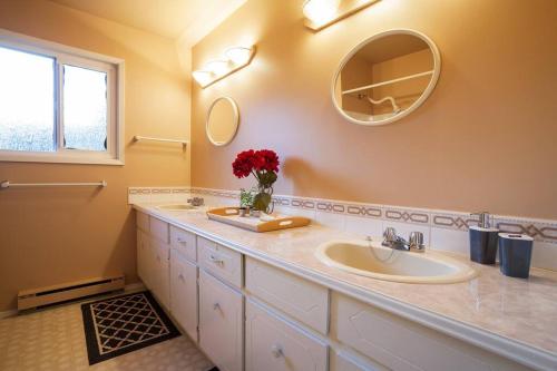 uma casa de banho com 2 lavatórios e um espelho em Spacious and Comfy ! em Victoria