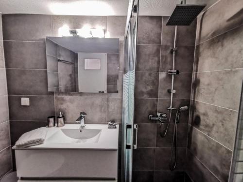 a bathroom with a sink and a shower at Silver Central Apartment in Volos
