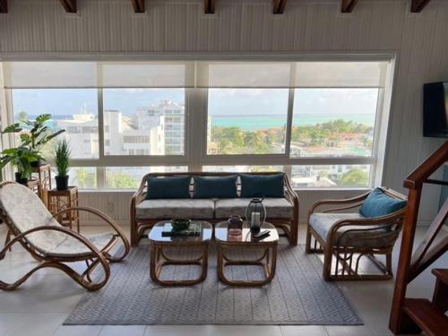 a living room with a couch and chairs and a large window at Lovely Penthouse with incredible view in San Andrés