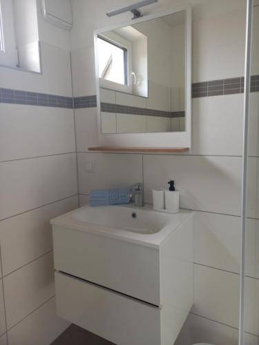 a white bathroom with a sink and a mirror at Privatzimmer an der Büffelweide in Gmünd