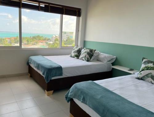 a bedroom with two beds and a large window at Lovely Penthouse with incredible view in San Andrés