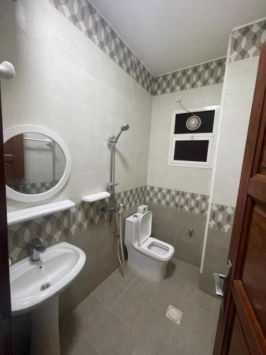 Un baño con lavabo, inodoro y espejo. en Red-15 - Bn Saif, en Salalah