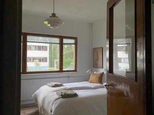 a bedroom with a bed with a window and a mirror at Aalto Apartments Sunila Honkala 1 in Kotka