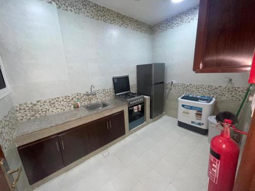 a kitchen with a sink and a stove in it at Red-15 - Bn Saif in Salalah