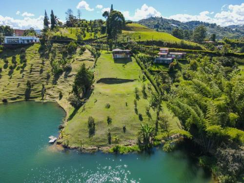 an island with houses on a hill next to a river at Loge Cabaña peñol-Guatape in El Peñol