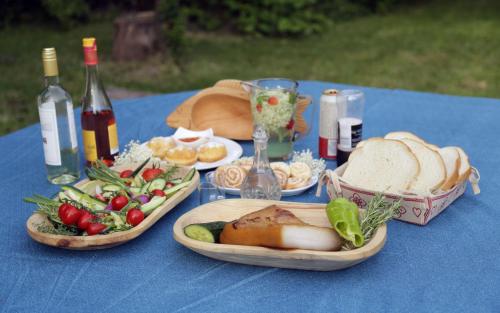 a blue table with plates of food and bottles of wine at Fónagy Apartmanok in Nagyvisnyó