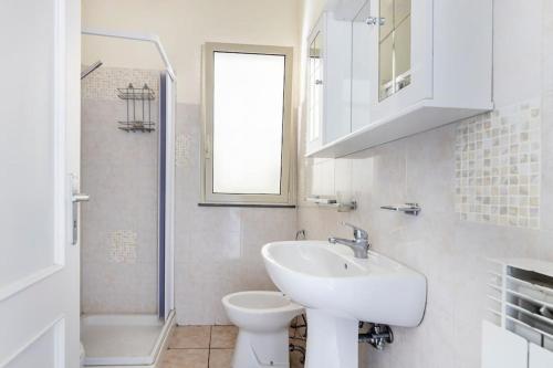 a white bathroom with a sink and a toilet at Affittacamere Bellavista in Castiglione di Sicilia