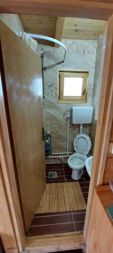 a small bathroom with a toilet and a window at Brvnara Beli Kamen 2 in Sremska Mitrovica