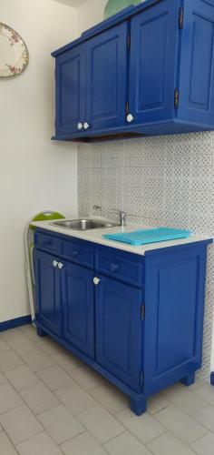eine Küche mit blauen Schränken und einem Waschbecken in der Unterkunft La Casa di Chico in Mondello