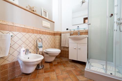 a bathroom with a toilet and a sink and a shower at Carìgnu in Tortolì