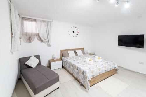 een witte slaapkamer met een bed en een stoel bij Carìgnu in Tortolì