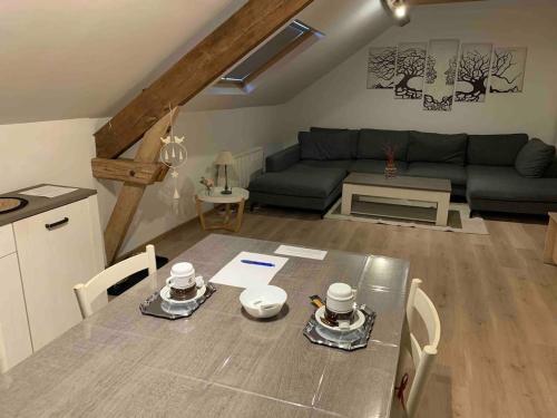 a living room with a table and a couch at 2pas2meuse in Waulsort