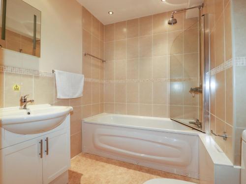a bathroom with a tub and a sink and a shower at The Dunes in Crantock