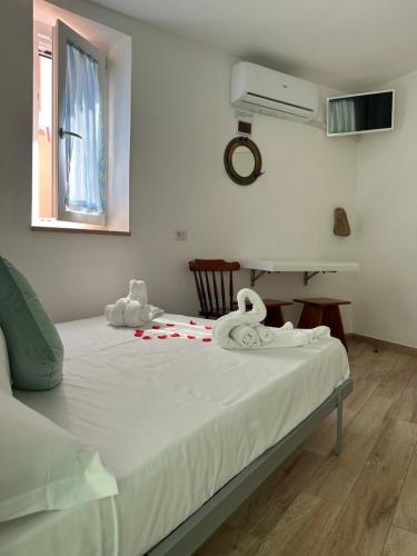 a bed with two white towels on top of it at Casa del Capitano - Suite Mediterraneo in Ponza