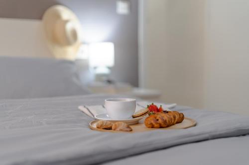 un vassoio con una tazza di caffè e croissant su un letto di Apartamento Salinas a Fuengirola