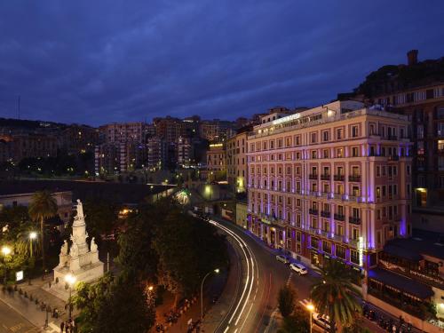 a view of a city at night with a building at Grand Hotel Savoia in Genova