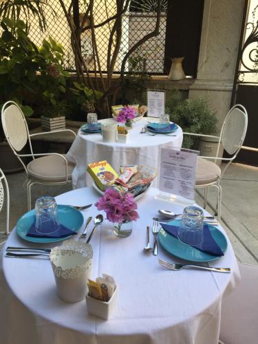 una mesa blanca con platos de comida. en Residenza Elisa en Desenzano del Garda