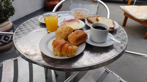 a plate of food on a table with coffee and bread at Posada Del Arbol in Capilla del Monte