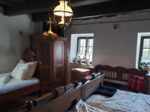a bedroom with a bed and a couch and a chandelier at Harmat Porta in Galambok