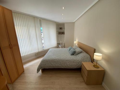 a small bedroom with a bed and a window at Apartamento La Duna de Gamazo en Santander in Santander