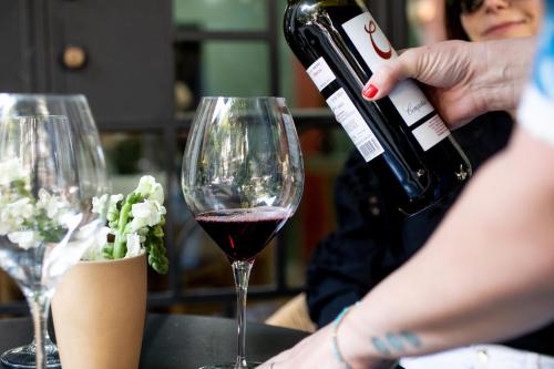 a person pouring wine into a wine glass at Hotel San Fernando in Mexico City