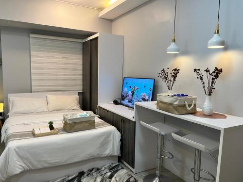 a bedroom with two beds and a desk with a laptop at Condotel Staycation Near NAIA Airport Okada DFA Manila Paranaque MOA in Manila
