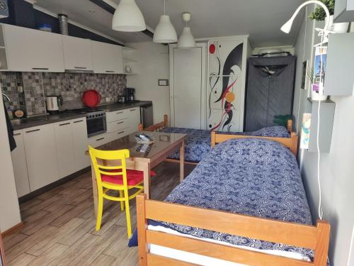 1 dormitorio con cama, mesa y cocina en Studio House - Getaway, en Bitola